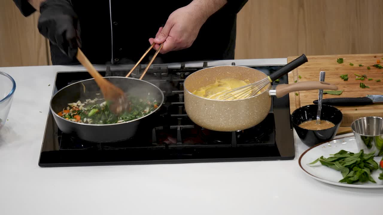 A chef expertly prepares a nutritious vegetable medley in one pan while boiling pasta in another. Fresh ingredients are used to create a colorful and healthy meal