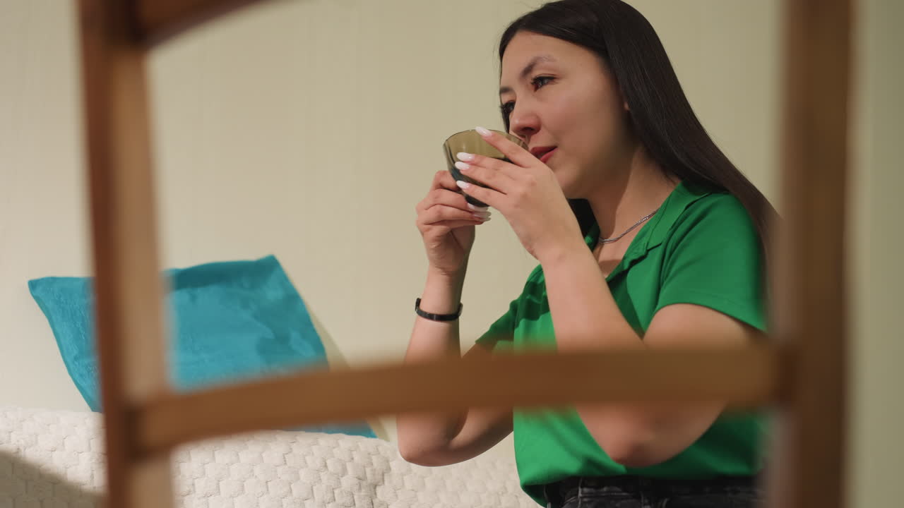 고요한 차를 마시는 순간, 평온한 분위기 속에서 즐기는 편안한 다도, 컵에서 평화롭게 차를 마시는 여인의 잔잔한 모습, 아늑한 침실에서 부드러운 숨소리와 함께 차를 마시는 차분한 의례