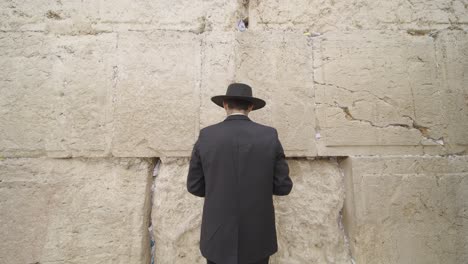man praying at the western wall in jerusalem