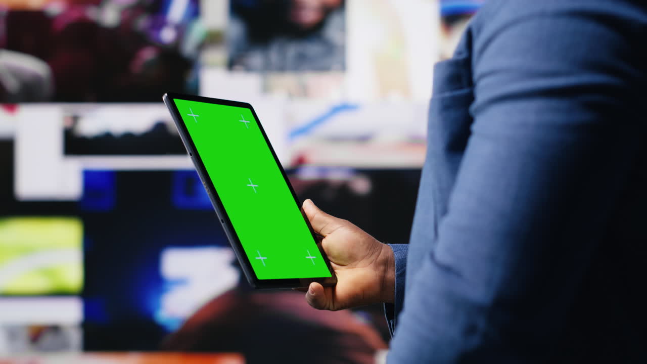 Appassionato di tecnologia afroamericano che guarda uno schermo chroma key.
