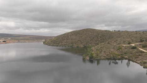 Toma-De-Drone-De-Una-Presa-En-Grabouw,-Ciudad-Del-Cabo-Adornada-Con-Montañas-Que-La-Rodean