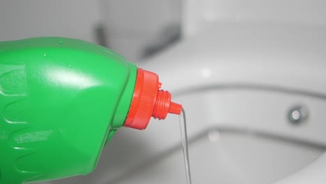 pouring toilet bowl cleaner into toilet