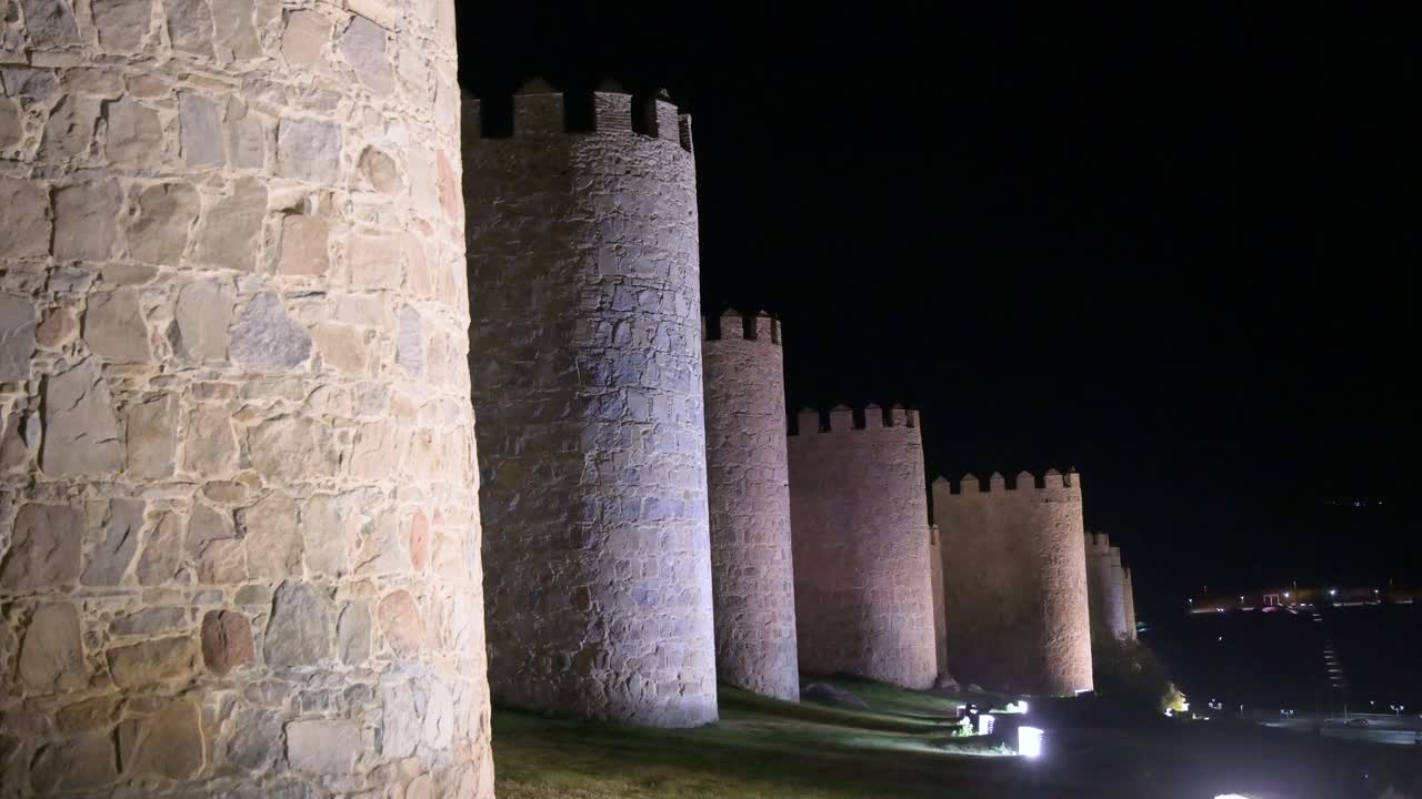 A night perspective of Avila’s old town, showcasing the lit-up medieval walls recognized by UNESCO in Spain.