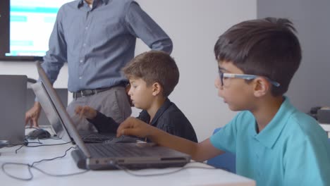 escolares sentados en el escritorio en el aula y haciendo tareas