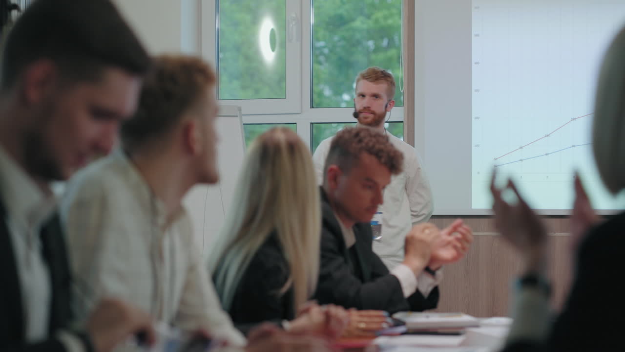 el especialista financiero está hablando en una reunión de negocios y mostrando el gráfico de crecimiento de las ganancias los colegas están aplaudiendo