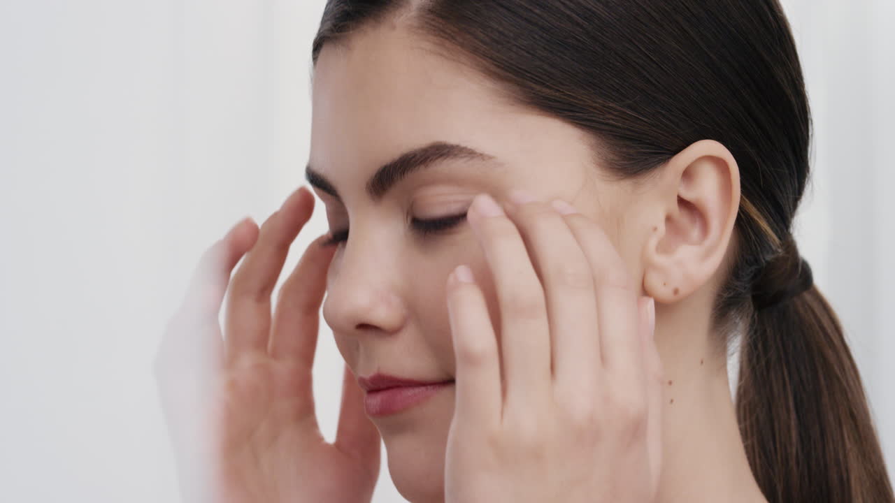 retrato de cerca de una mujer joven hermosa tocando suavemente la piel con las manos acariciando una tez suave y suave sonriendo disfrutando de una belleza natural perfecta concepto de cuidado de la piel de lujo