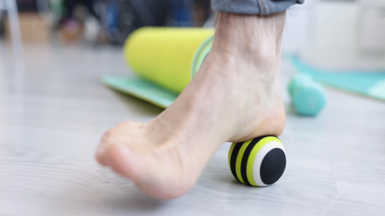 Person Massaging Foot with Therapy Ball