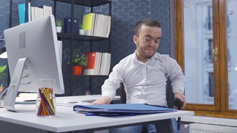 um anão deficiente a trabalhar no computador no escritório.