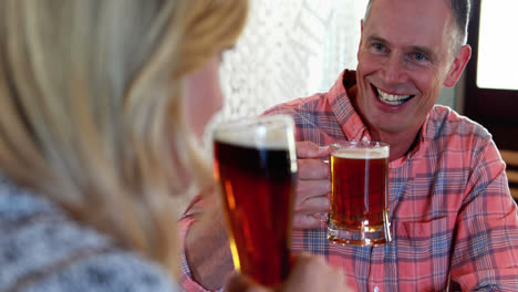 couple interacting while toasting a glass of beer at bar counter 4k