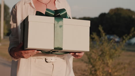 Confident-woman-walks-down-the-street-with-a-gift-in-her-hands