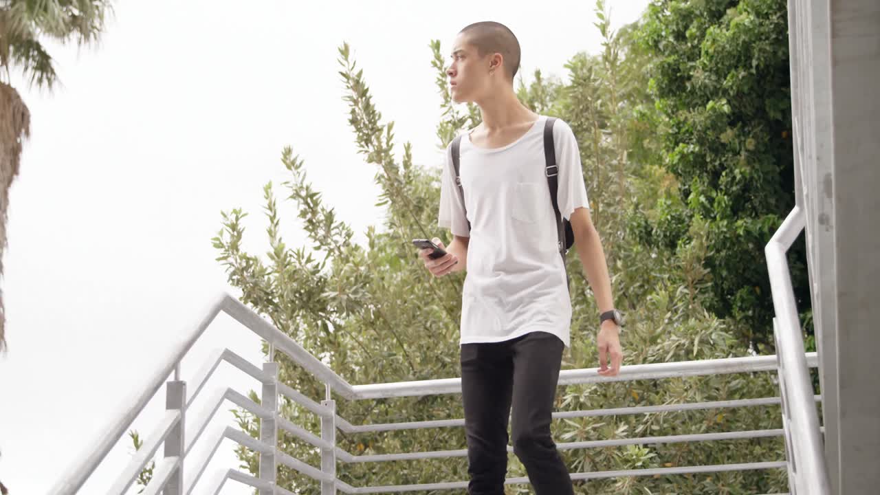 hombre bajando las escaleras mientras sostiene el teléfono móvil 4k