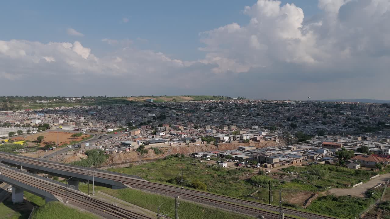 드론 장면: 요하네스버그의 도시 풍경을 포착하는 등반, 타운십과 철도 위로 상승하여 도시 풍경과 교통 인프라에 대한 설득력있는 시야를 제공합니다.