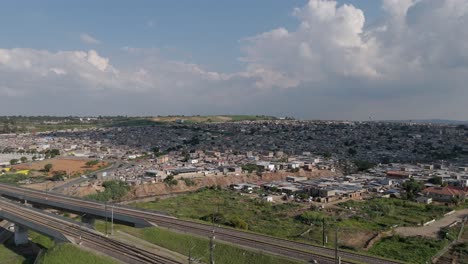 drone footage, a climbing shot captures the cityscape of johannesburg, ascending over a township and railway, offering a compelling view of the urban landscape and transportation infrastructure