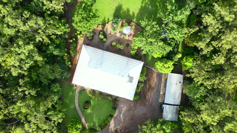 aerial drone of tropical rural estate large block property with grassy backyard and long shadows from trees