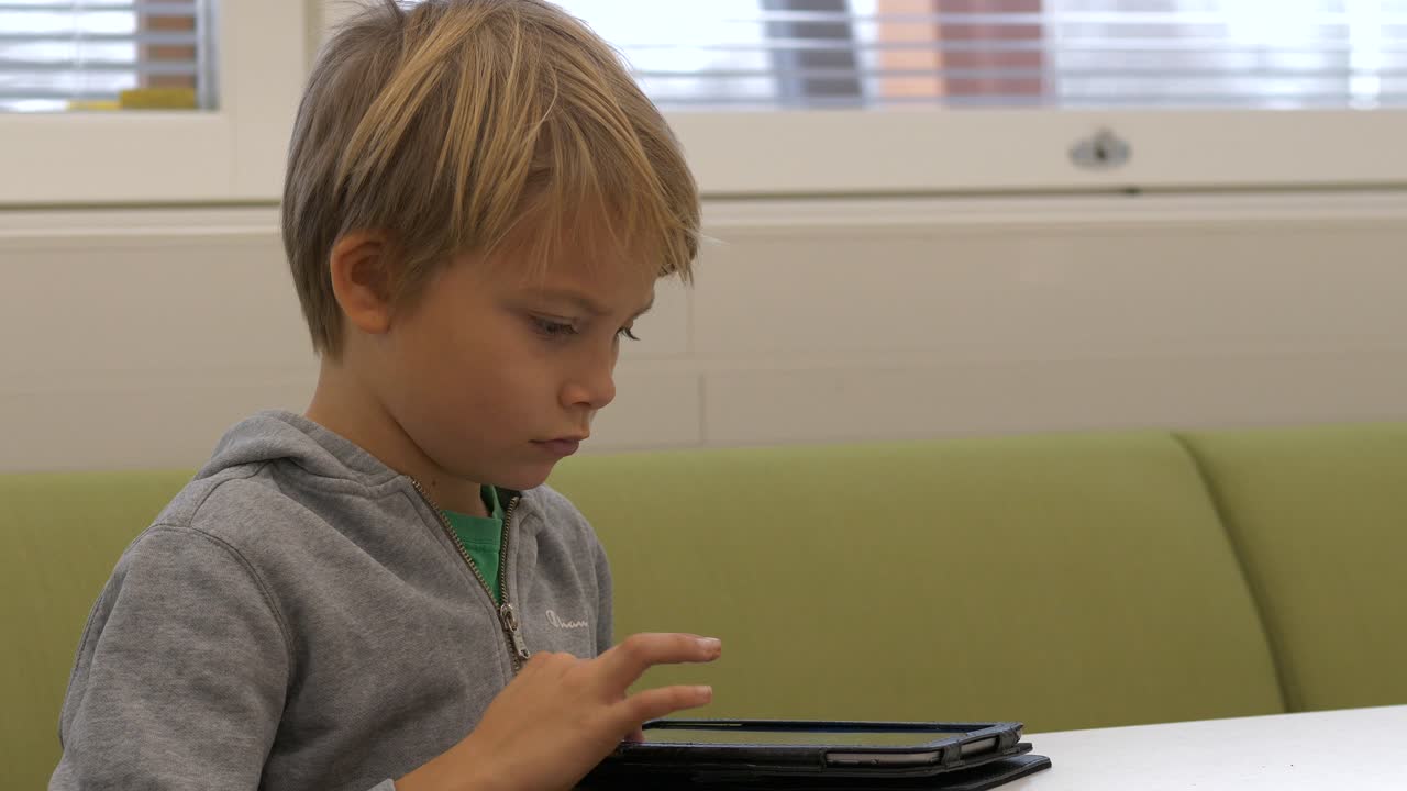 tableta de surf de estudiante elemental nórdico joven, cámara lenta