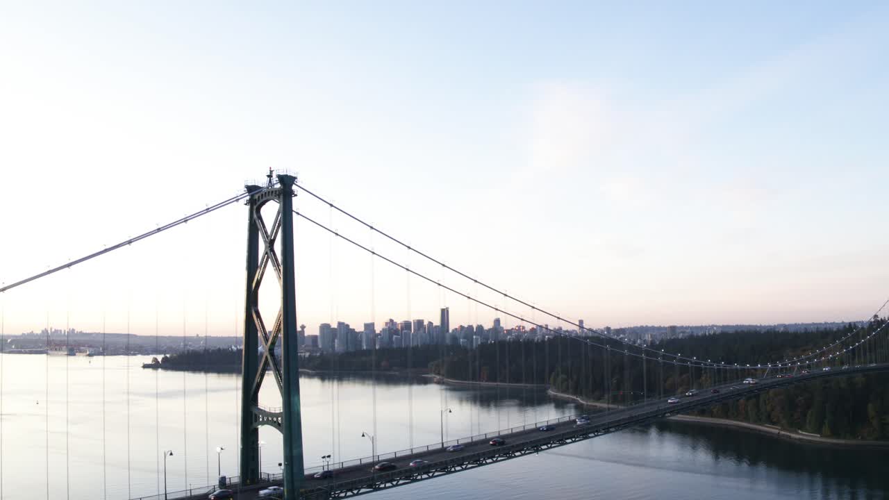 아침에 라이온스 게이트 다리의 4k 항공 영상으로 밴쿠버와 스탠리 파크가 다리에서 멀어지는 것을 보고 있습니다.