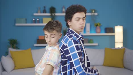dos hermanos con las espaldas uno al otro.