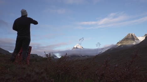 Excursionista-Tomando-Un-Descanso-Con-Espectaculares-Montañas-En-El-Fondo