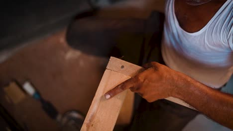 Primer-Plano-De-Un-Carpintero-Trabajando-En-Su-Taller,-Carpintero-Martillando-Clavos-En-Un-Trozo-De-Madera,-Carpintero-Haciendo-Piezas-De-Muebles