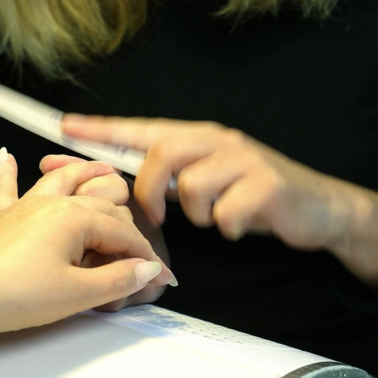 una mujer haciendo una manicura de uñas.