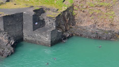 people cliff jumping into a quarry
