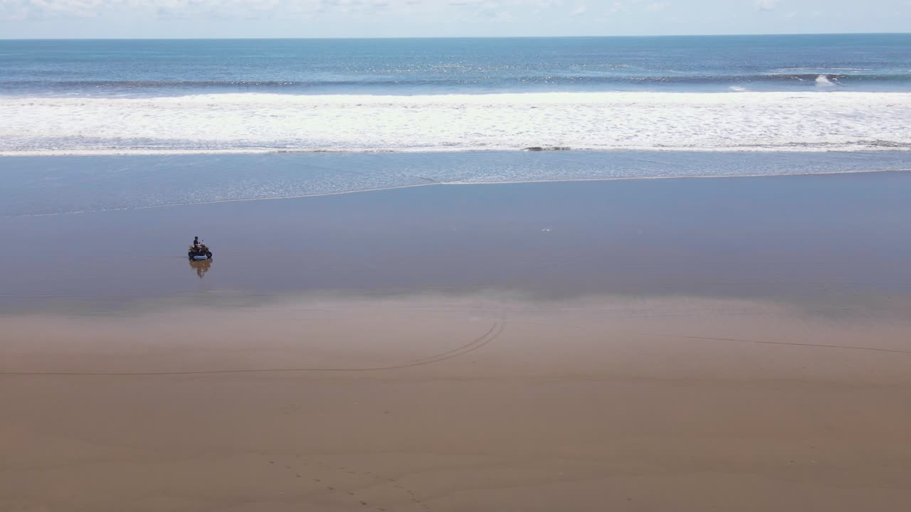파도가 해안에 충돌하는 동안 해안선을 따라 천천히 움직이는 자전거 타기
