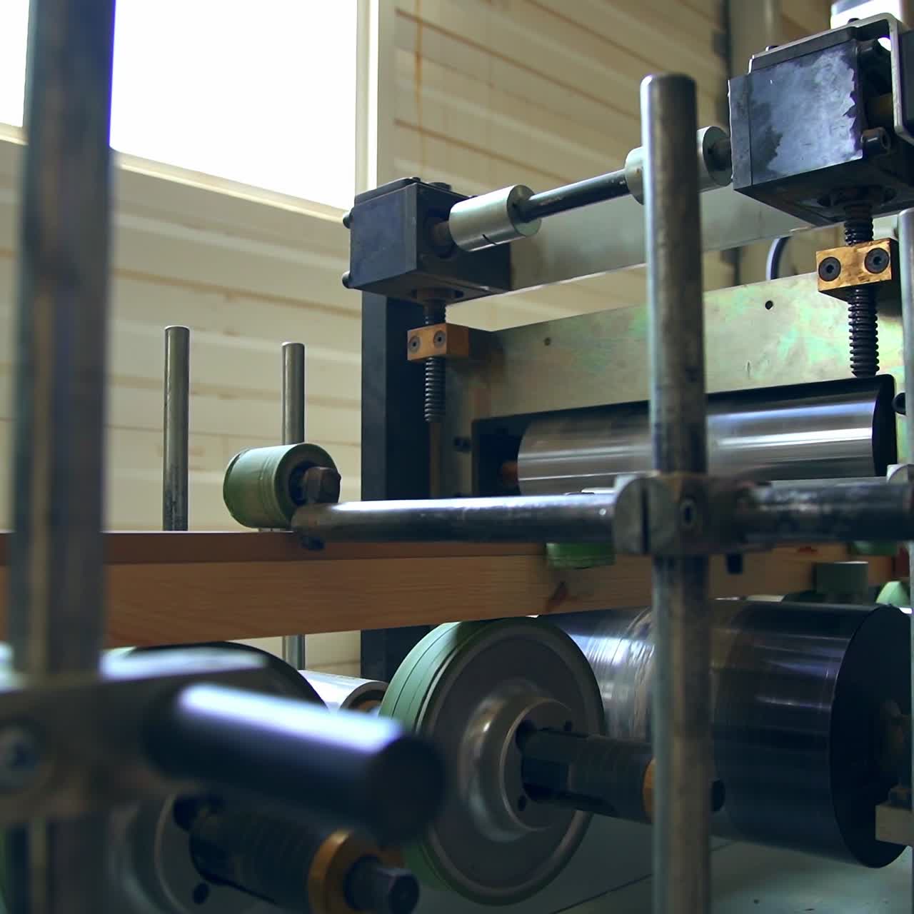 Equipment with multiple rollers of diverse width. Shafts rotate and move the timber bar further. Door manufacturing company