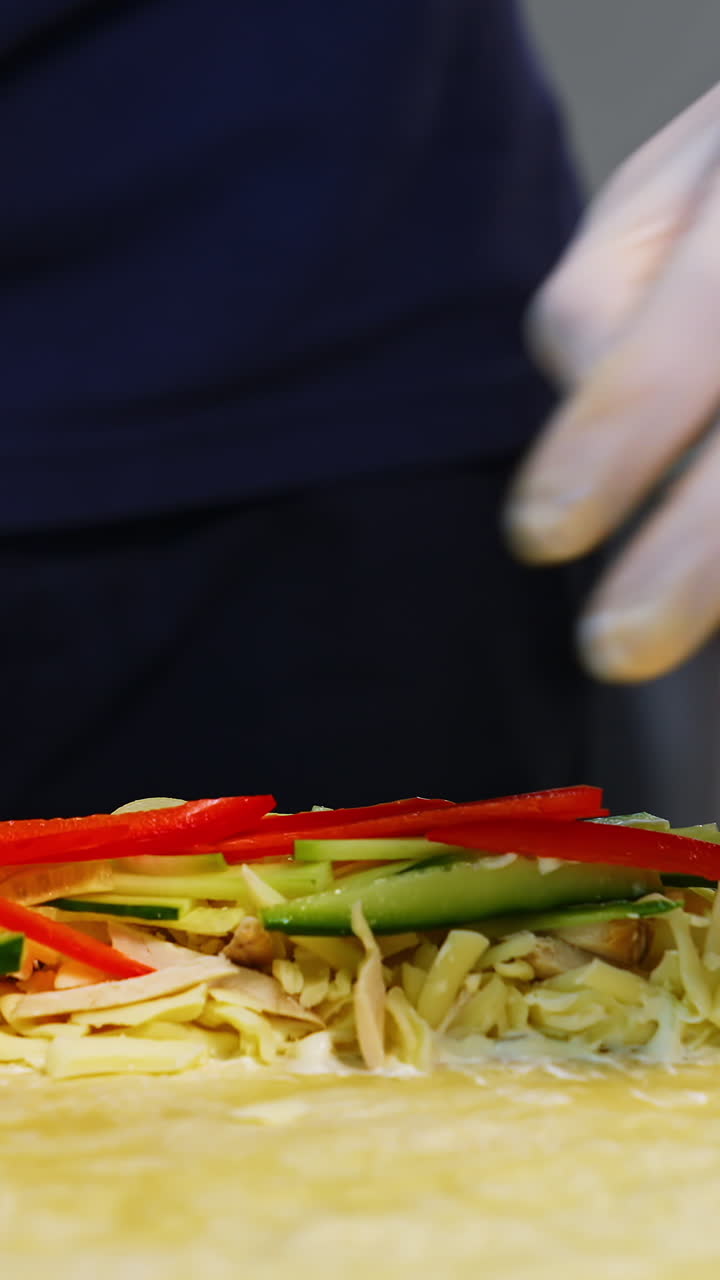 Cooking meal in fast food restaurant. Professional cook in white gloves puts filling with cutted vegetables into pita. Process of cooking tasty snack. Vertical video