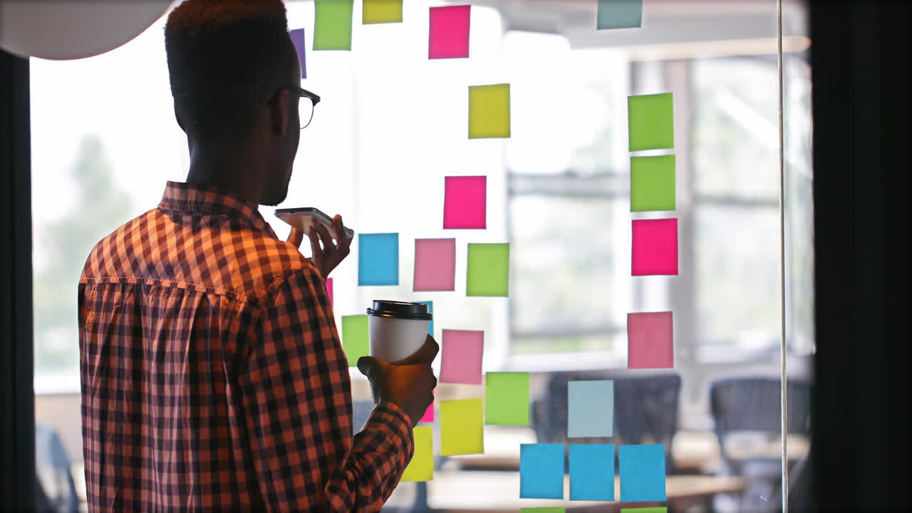 Male executive with coffee cup talking on mobile phone 4k