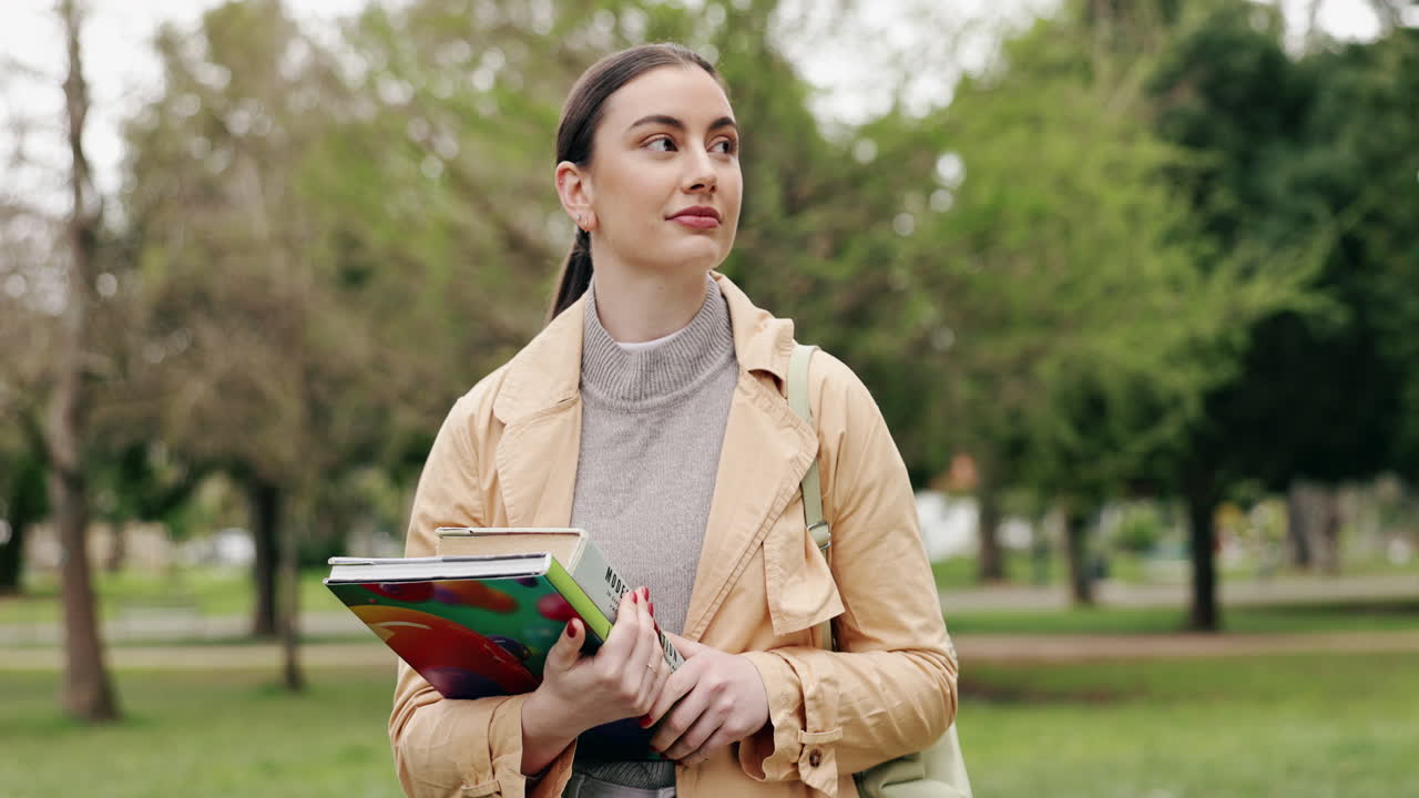 Studente che passeggia nel parco con libri