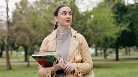 estudiante caminando en el parque con libros