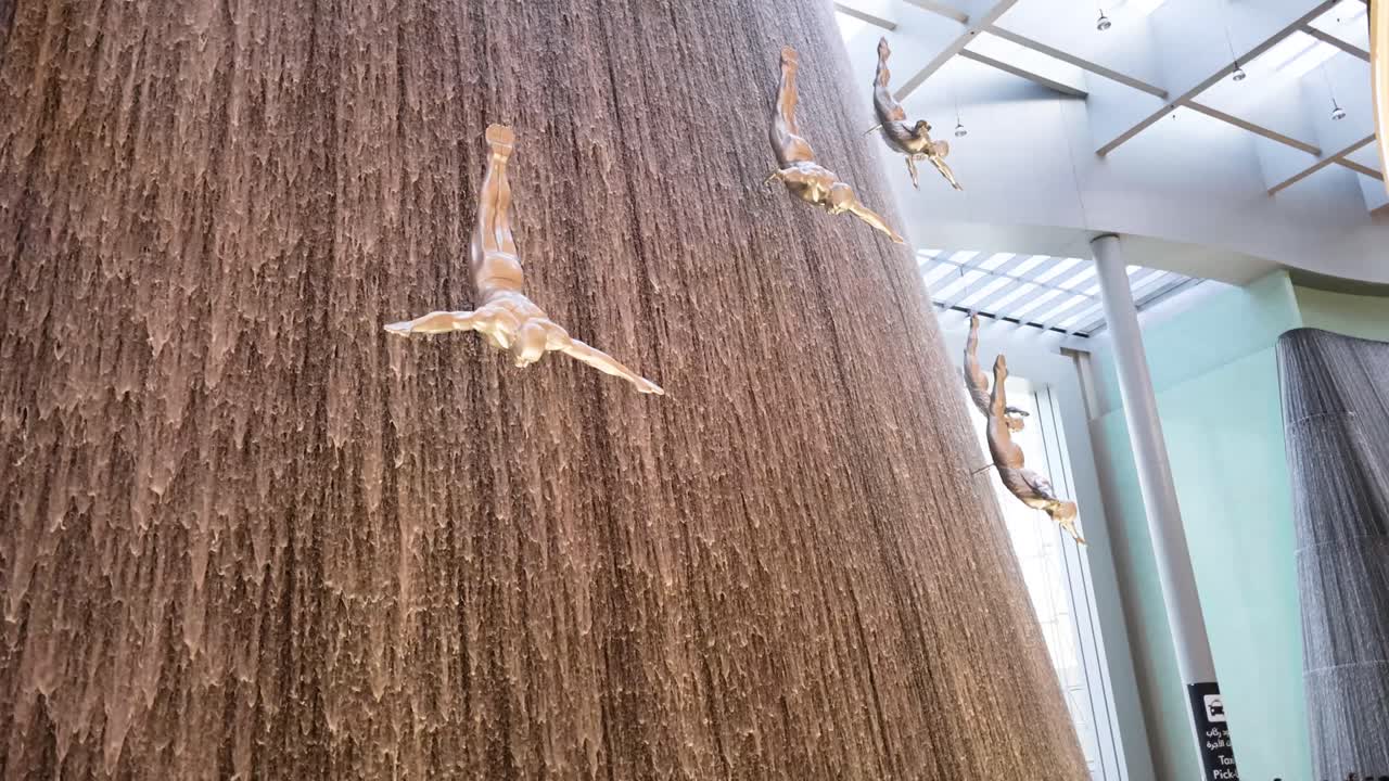 esculturas de buzos en la cascada del centro comercial de dubái