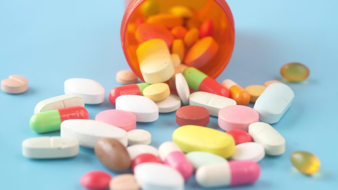 오렌지색 병에서 흘러내린 다양한 약과 태블릿