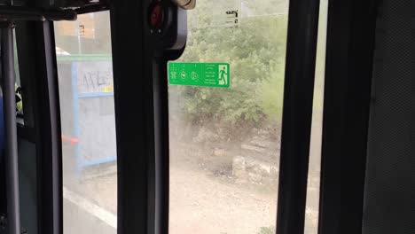 a bus is parked in front of a building with a green sign on the side