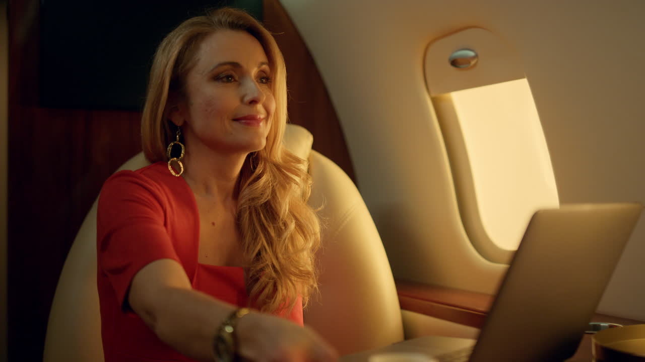 mujer rica viajando en un avión de negocios en primer plano. mujer atractiva a la luz del sol