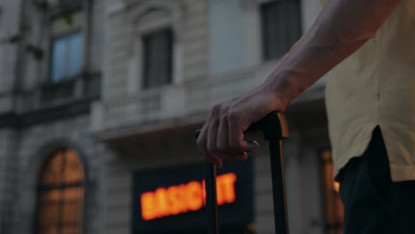 person with a suitcase walking down a city street