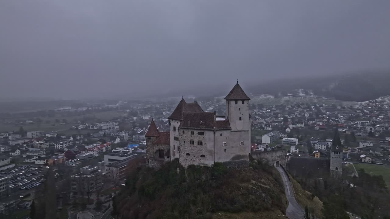 A medium-distance orbital shot of Gutenberg Castle, with the village of Balzers in the background