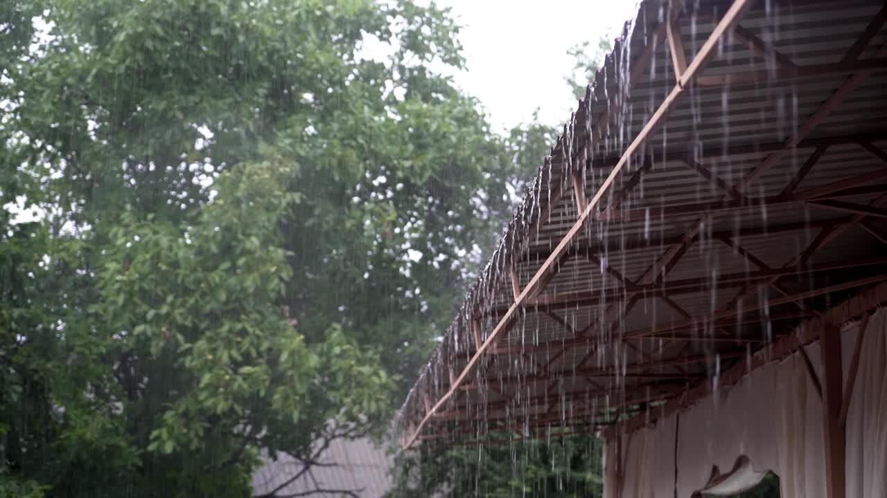 Rainy Day. Drops of rain fall from the roof of the pavilion. Raindrops flow down. Close-up.