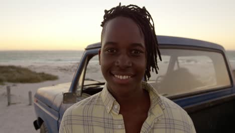 Man-looking-at-camera-near-pickup-truck-at-beach-4k