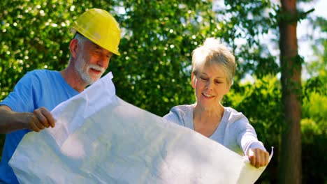 Senior-couple-looking-at-map-in-garden