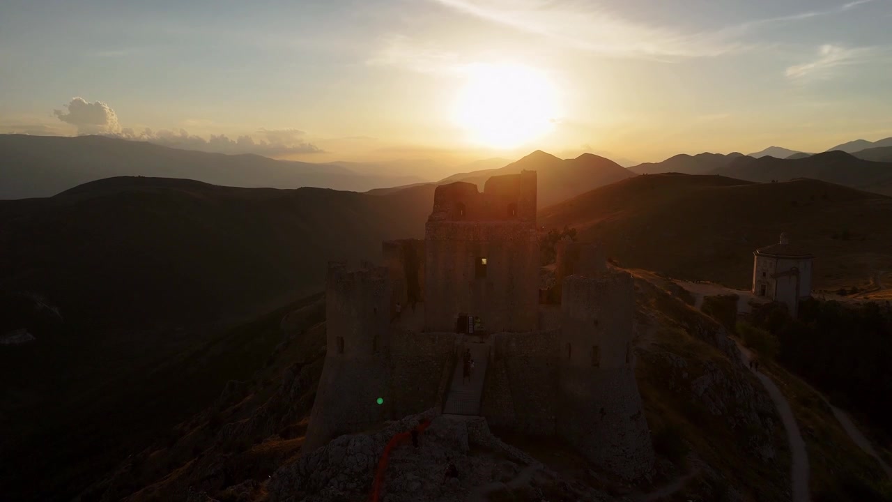 Vista aérea en silueta del famoso castillo medieval, la fortaleza de Rocca Calascio al atardecer, situado en una alta cresta montañosa sobre el espectacular paisaje de los Apeninos en Abruzos, Italia