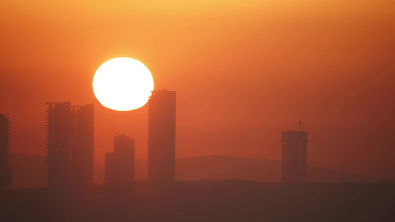 O pôr-do-sol sobre o horizonte da cidade com silhuetas de edifícios