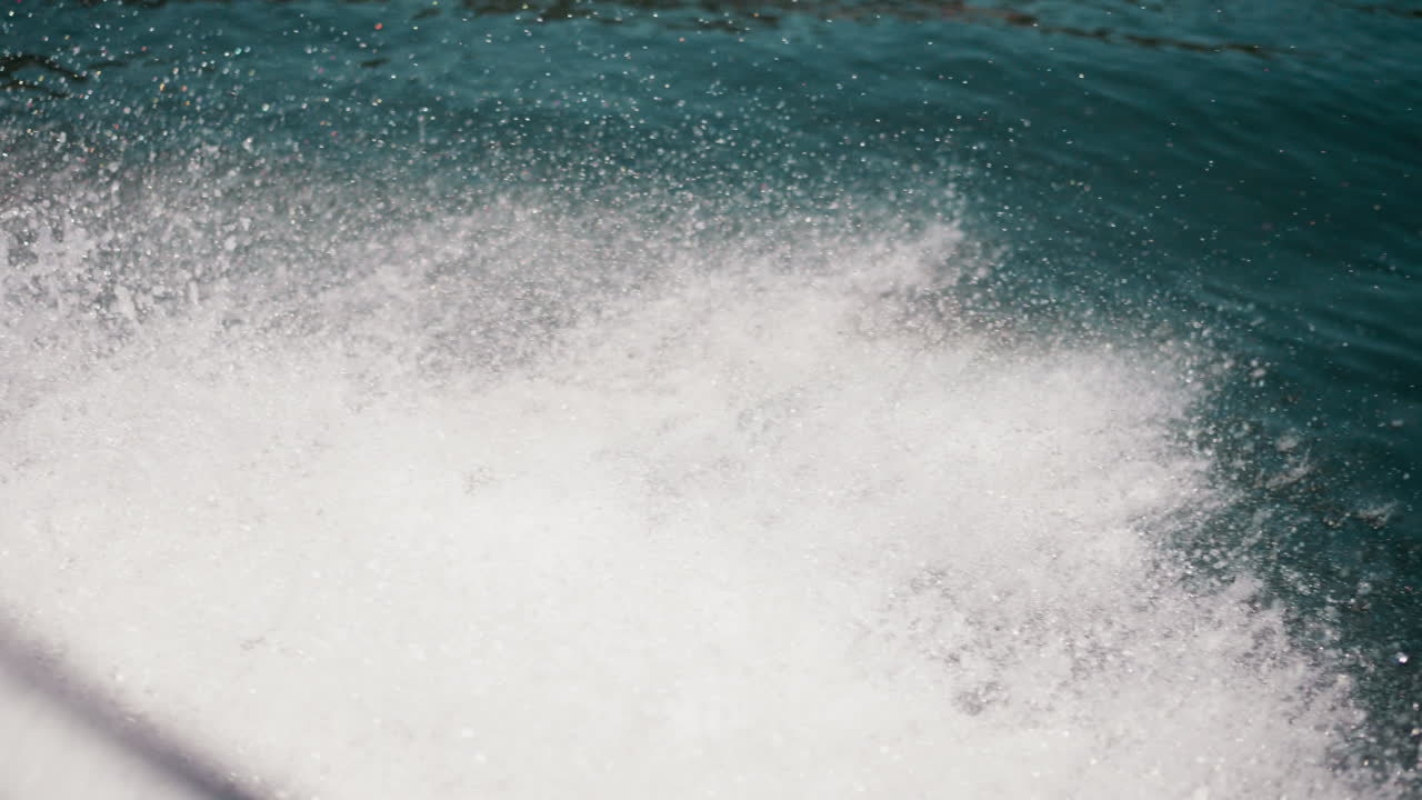 여름날에 평온한 물 위에 항해하는 빠른 보트의 흔적, 모터 보트의 뒤에 있는 바다 표면에 있는 거품 모양의 트랙, 바가에서 활발한 여가
