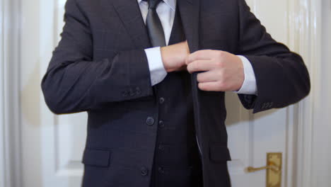 an unrecognizable groom or best man reads his speech notes on a piece of paper then folds it up and places it in his business or wedding suit jacket pocket