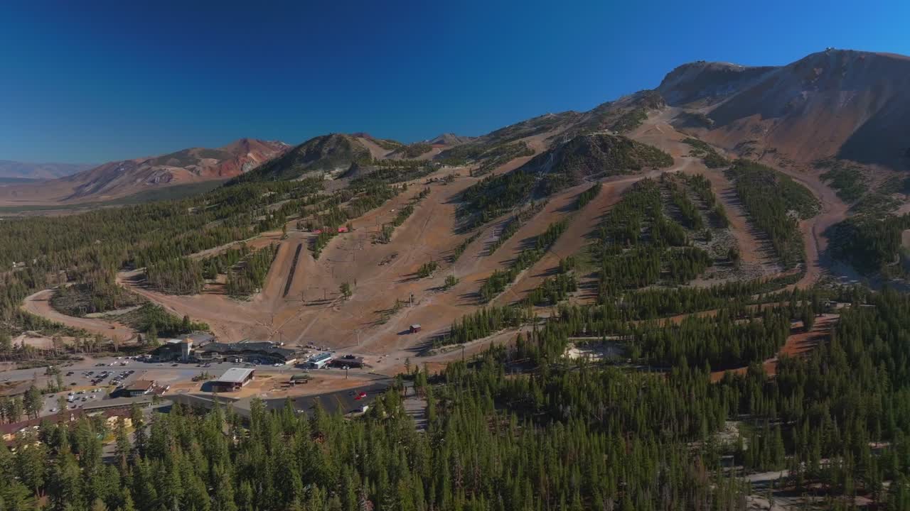 Mammoth Lakes Mountain Ski Area Minarets Upper Panorama Gondola summer autumn fall aerial drone California McCoy Station main lodge parking lot sunny daytime blue sky chairlift gondola forward motion