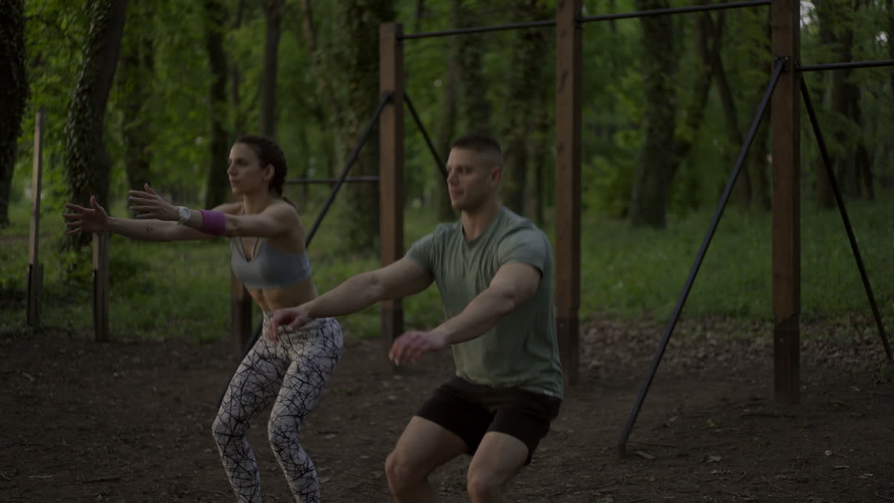 Couple Exercising Together Doing Squats Outdoors