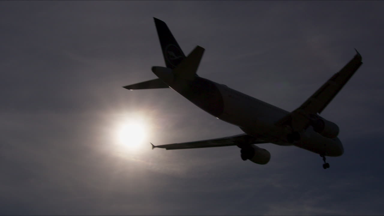 Airplane Landing/Takeoff Silhouette Against Sky and Sun