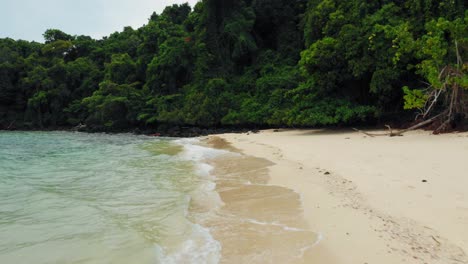 dolly shot of waves crushing into tropical sandy beach on paradise island in thailand