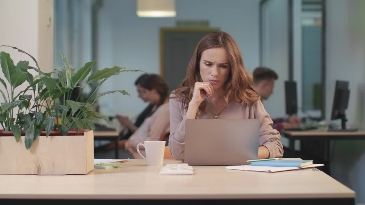 Donna d'affari che lavora al computer in coworking. Ritratto di donna concentrata.