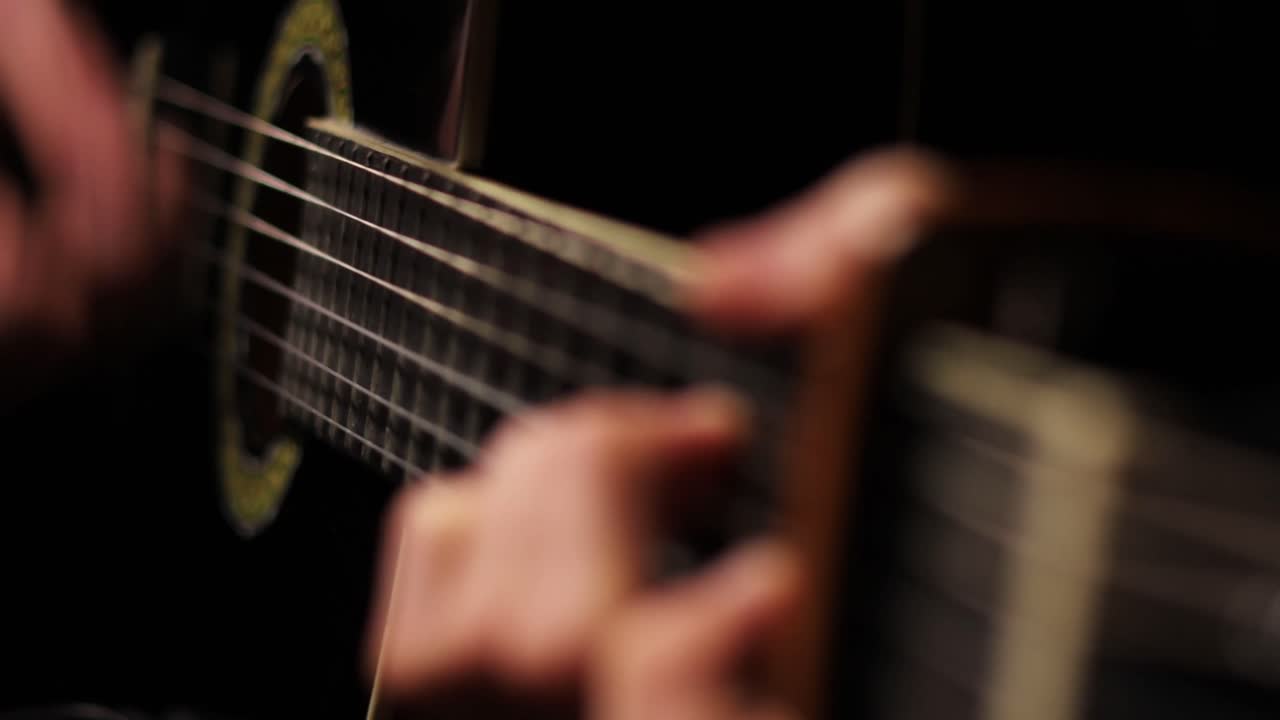 foto de detalle del guitarrista rasgueando su guitarra